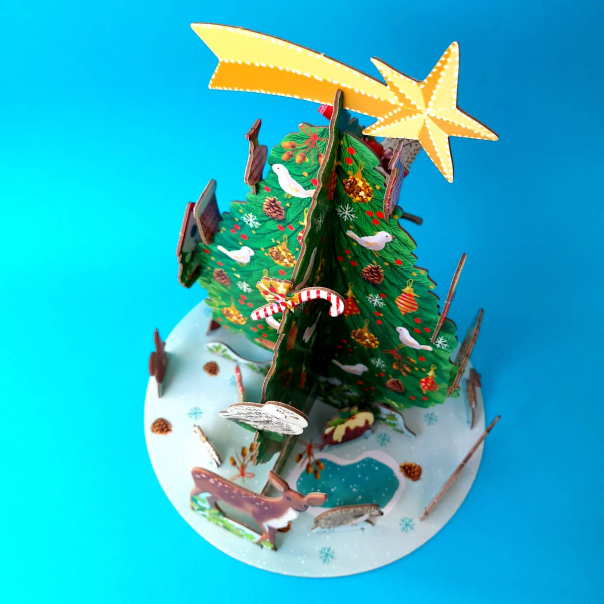 Decorative Christmas tree model with animals and a star on a blue background