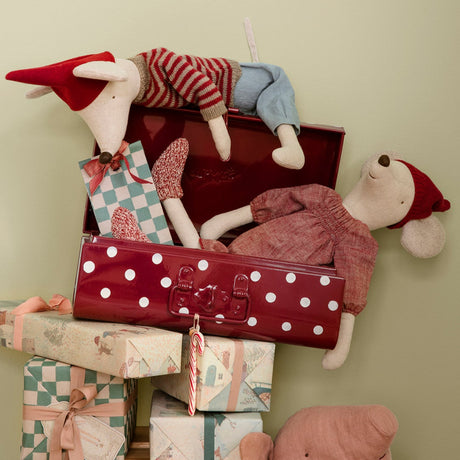Stack of gift boxes with toys on a wooden stand against a light green wall